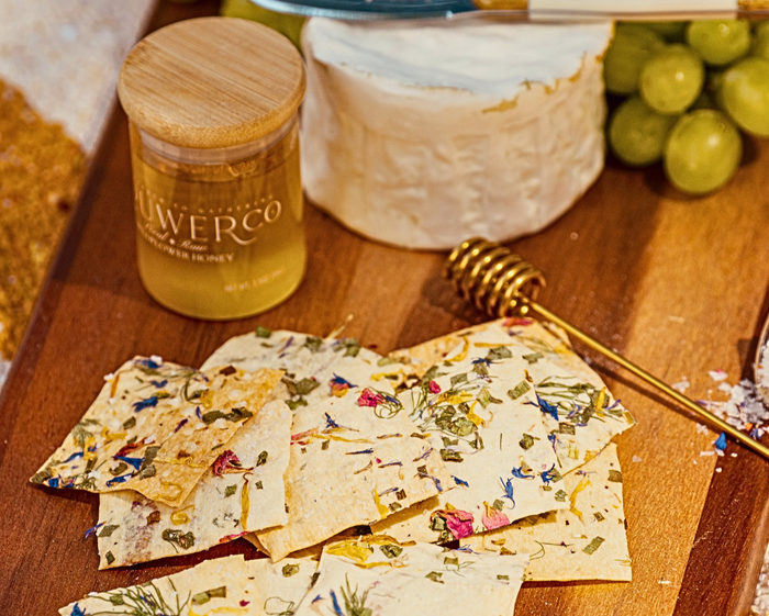 Flouwer Co. Artisanal Crackers, featuring a vibrant topping of edible flowers and herbs