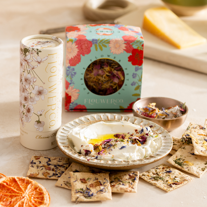 Artisanal floral crackers served around whipped feta dip with olive oil, dried petals